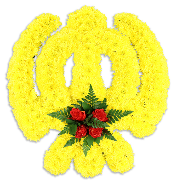 Captured on a clean white field, this Khanda-shaped floral tribute is a study in colour, form and respect: thousands of bright yellow chrysanthemum blooms have been arranged with exacting precision to delineate the circular chakkar, the central double-edged blade and the crossed kirpans, producing a rounded, softly elevated relief that reads as both emblem and textile. At the very centre, where the emblem converges, five to six deep red roses form a concentrated focal point - their layered petals offering a velvety counterpoint to the feathery chrysanthemum heads - and are ringed by lush, dark green fern fronds which sharpen the composition's contrast and lend a natural border. A soft shadow beneath the piece confirms its status as an actual floral board or freestanding tribute intended for ritual or memorial placement, perhaps at a gurdwara service, a remembrance event, or a community funeral near Elmers End and neighbouring South Norwood. The yellow tone emits a warm, sunlit optimism while the roses quietly assert love, memory and reverence; together they create an emotional balance appropriate for public and private observances. Texturally, the arrangement alternates between the chrysanthemums' dense, almost cushion-like surface and the roses' smooth, sculpted heads, the fern adding a final crispness. The image conveys not just a design but a practiced floral craft, the thoughtful choices of colour and foliage reflecting experience in producing respectful, locally delivered tributes for families in and around Elmers End.