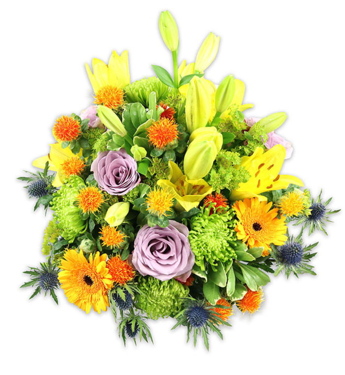 A richly hued and professionally composed floral bouquet sits against a crisp white background, its colours and textures described with the care of a florist who knows Elmers End's streets and Saturday trade. The arrangement centres on several golden-yellow Asiatic lilies: some fully unfurled with speckled throats and visible stamens, others held as slender, upward-reaching buds that suggest unfolding stories. Pairing with those are soft lavender-purple roses, their layered petals creating a cool, tender heart to the design and lending a faint, nostalgic fragrance. Sprays of vibrant orange Gerbera daisies fan out across the surface with bold, cheerful faces and darker centres that catch the gaze. Abundant chartreuse green 'button' chrysanthemums and rounded pom-poms build a soft, ruffled volume that makes the bouquet feel generous and tactile. Interspersed are small, spherical orange-yellow accent blooms-round, slightly spiky, and decidedly playful-which add rhythm and a modern touch. Distinctive blue-grey sea thistles (Eryngium) project from lower and side positions, their metallic-blue spiky bracts giving structural contrast and an unexpected sculptural element against the warm palette. Layered foliage-broad lily leaves, slender stems, and glossy filler greens-frames the flowers, adding depth and unifying the composition. The scent profile would be a delicate blend of rose sweetness and fresh lily-green notes, with the thistles contributing a clean, slightly bracing aroma. This bouquet, crafted with neighbourhood sensibility and attention to balance, suits celebrations, grateful gestures, or as a striking centrepiece for a home or small event in Elmers End or nearby Beckenham. Elmers End Florist would prepare such an arrangement with local care.
